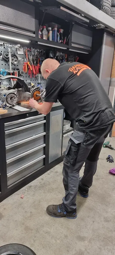 Timmy van Thunder Racing aan het werk aan een scootermotor