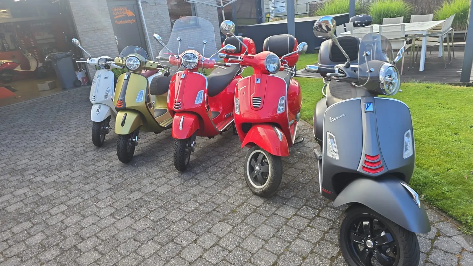 Scooters Vespa neufs devant le garage Thunder Racing à Geel